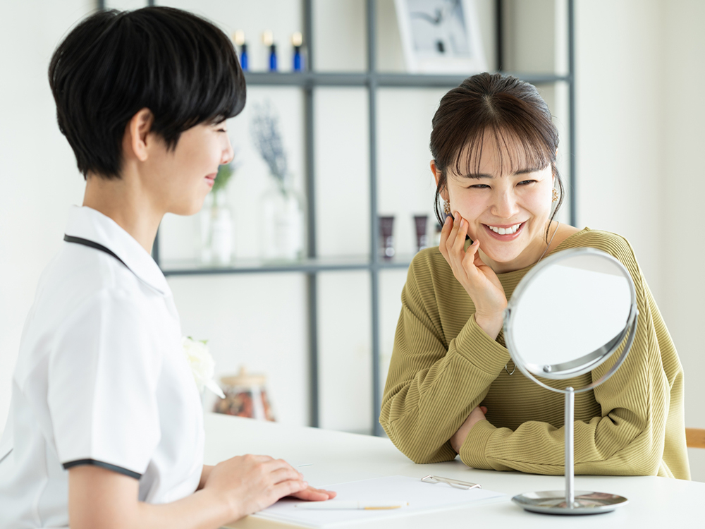 エステティシャンとお客様が、一緒に鏡を見て結果を喜び合う場面